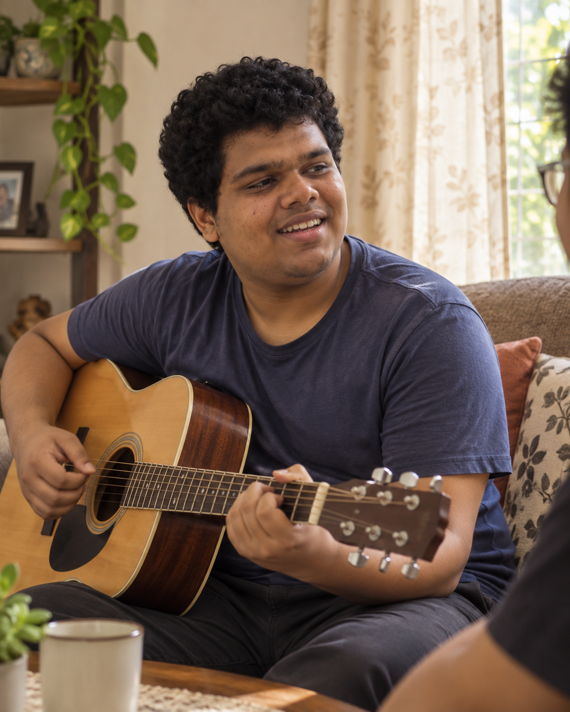 Conceptual candid-style portrait of Yethikrishna R singing with an acoustic guitar in a living room setting.